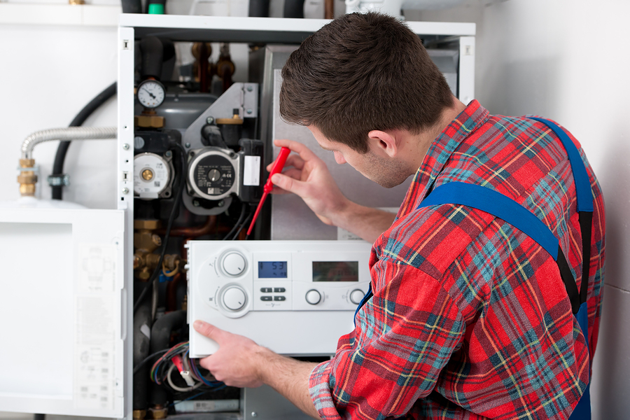 man working on thermostat
